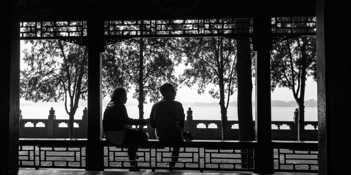 A black and white silhouette of 2 people by the park, Beijing, China.