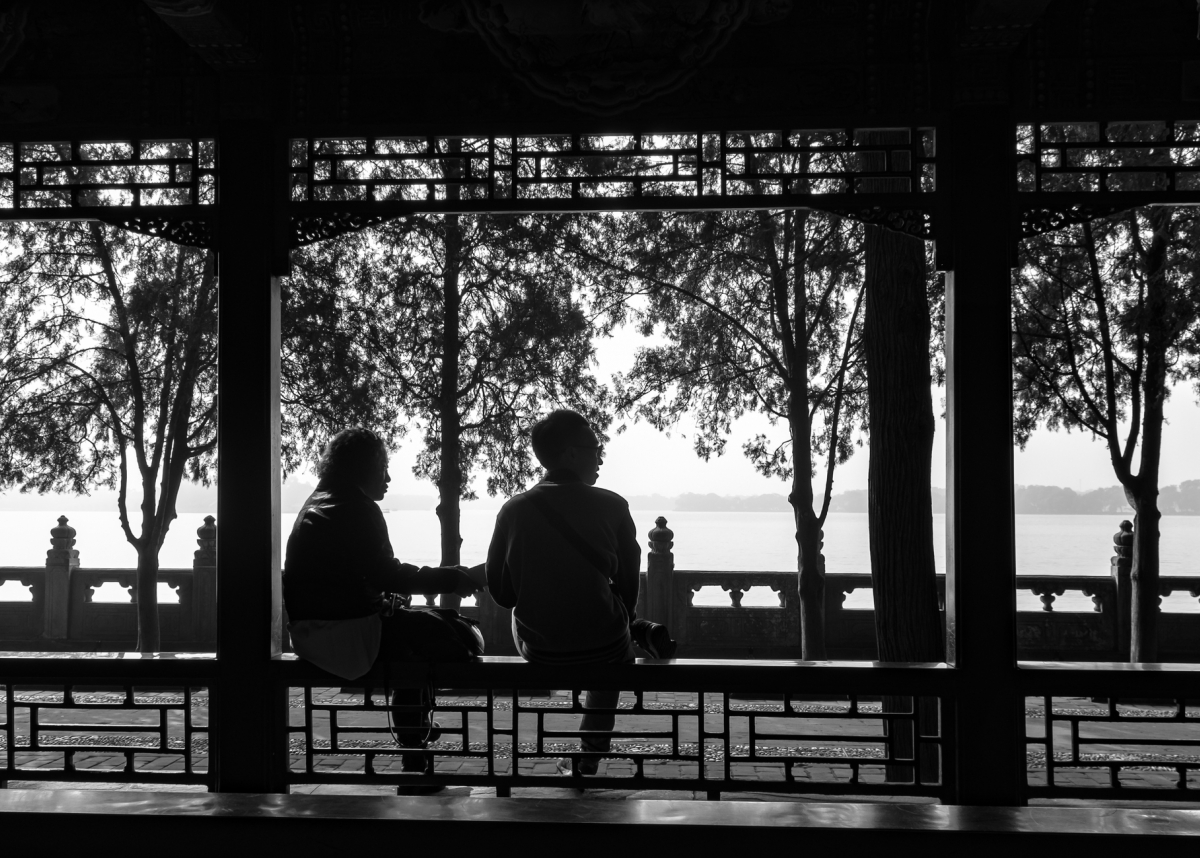 A black and white silhouette of 2 people by the park, Beijing, China.