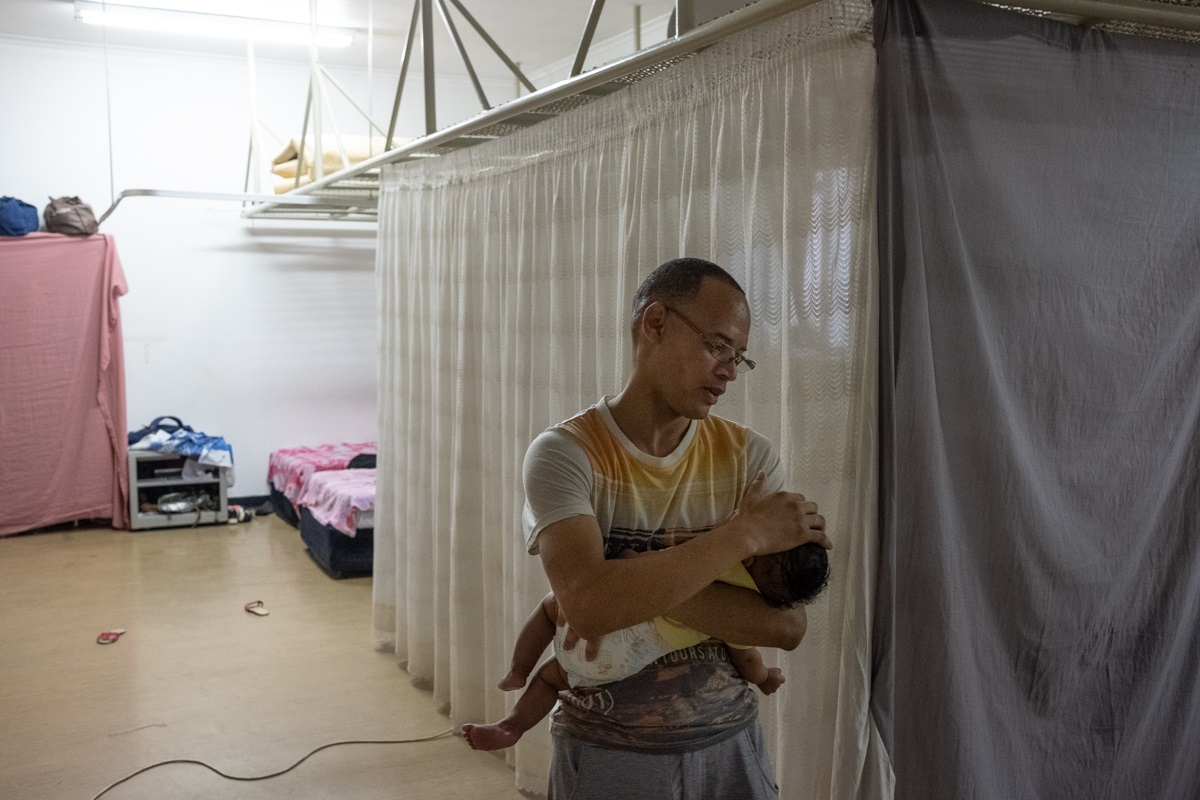 man with his baby living in disused hospital ward